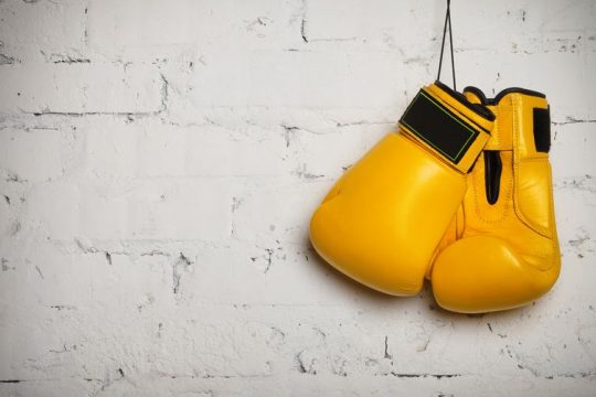 Žlté boxerské rukavice zavesené na stene