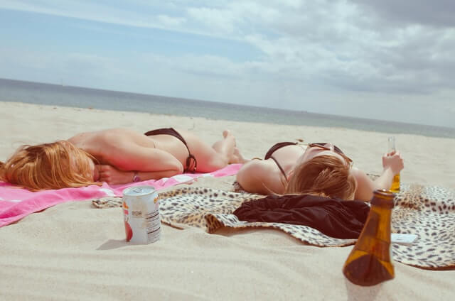 Dve mladé ženy opaľujúce sa na slnku počas horúcich letných dní.