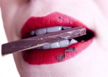 žena s čokoládou v ústach